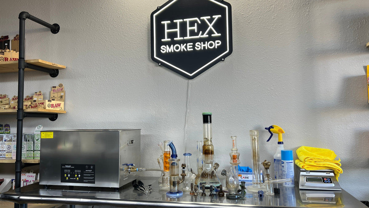 Glass water pipes and ultrasonic cleaning station at Hex Smoke Shop in Adelanto California