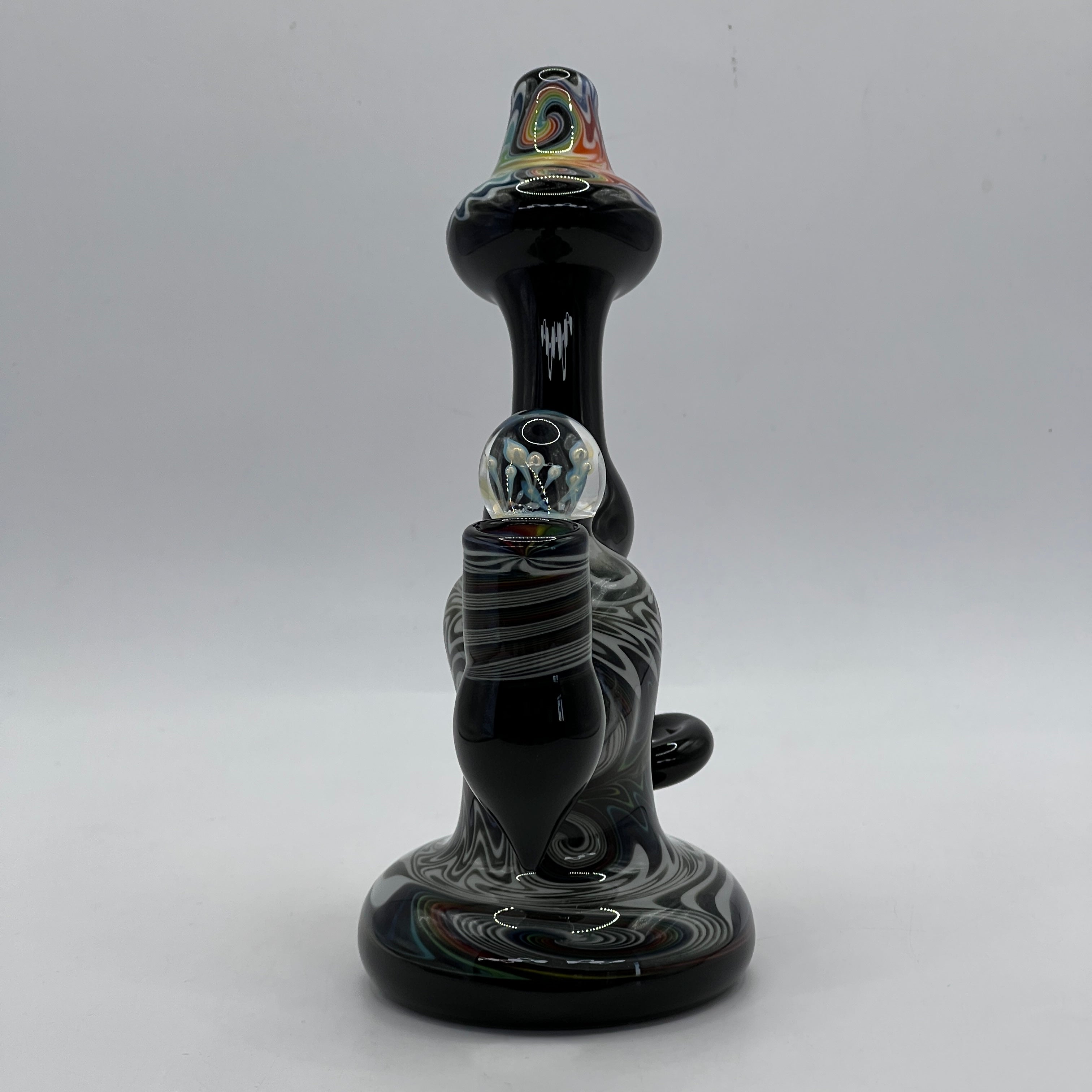 Front view highlighting rainbow mouthpiece and sculptural marbles