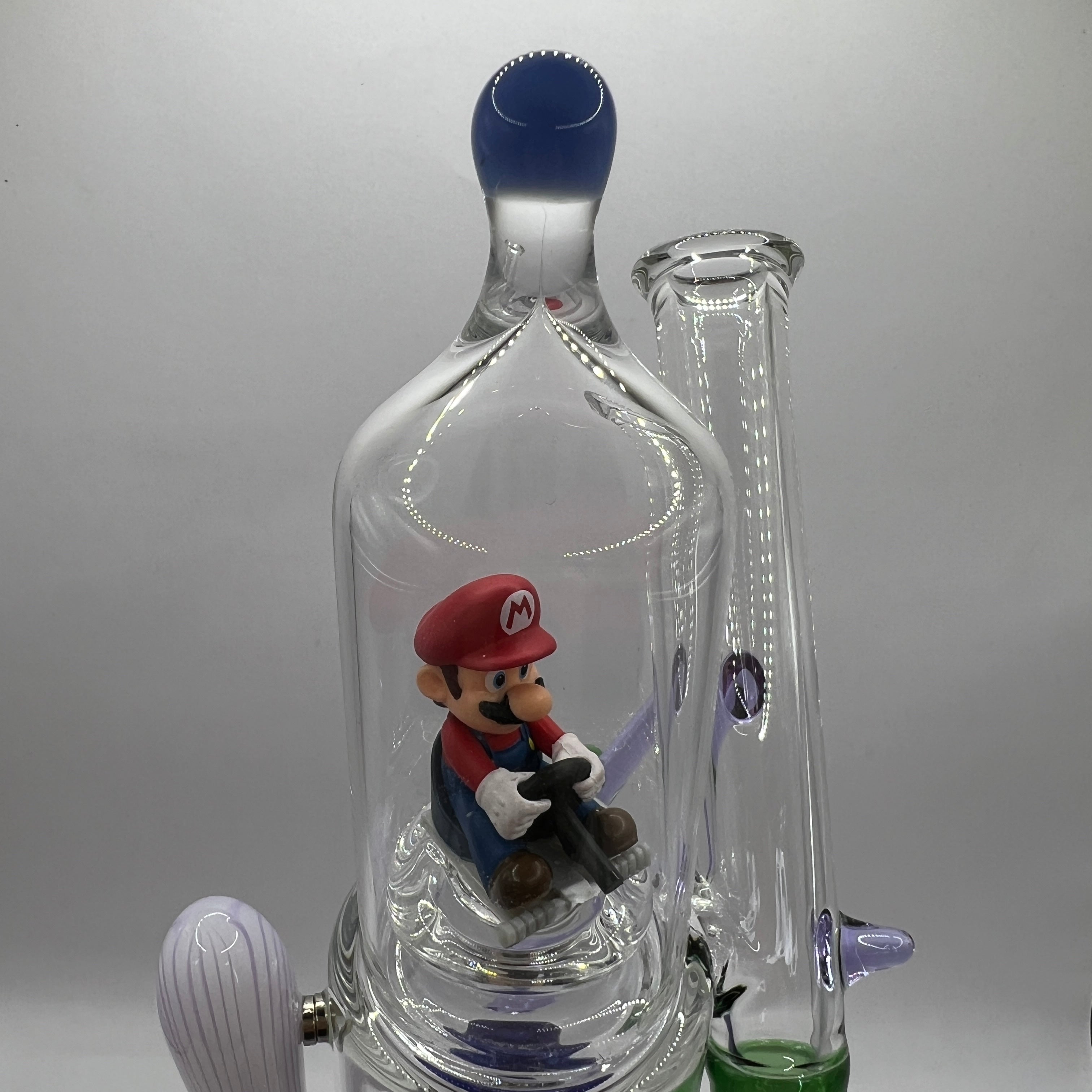 Front close-up of Mario figure enclosed inside the OTG Glass water pipe