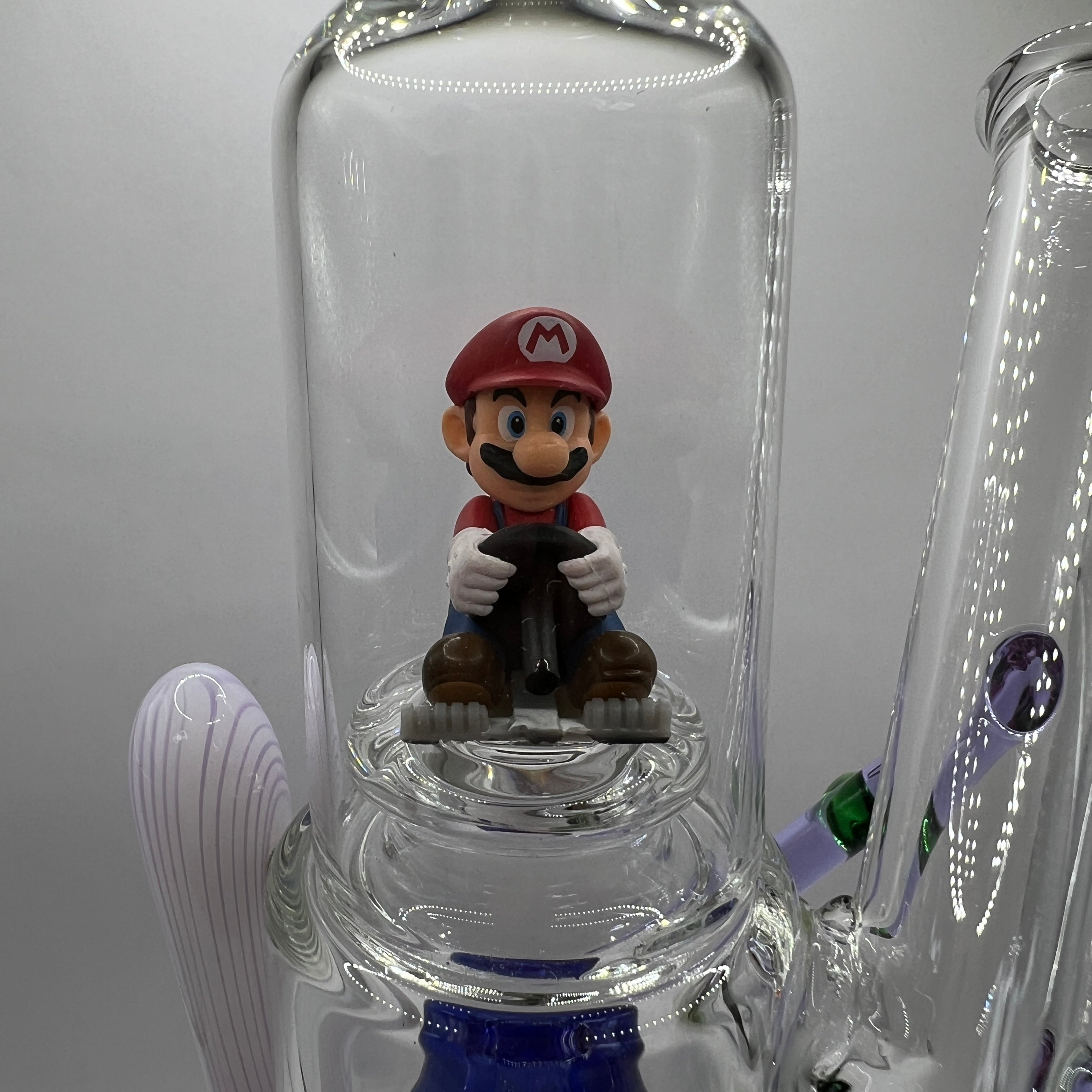 Close-up of Mario figurine inside the upper glass display chamber