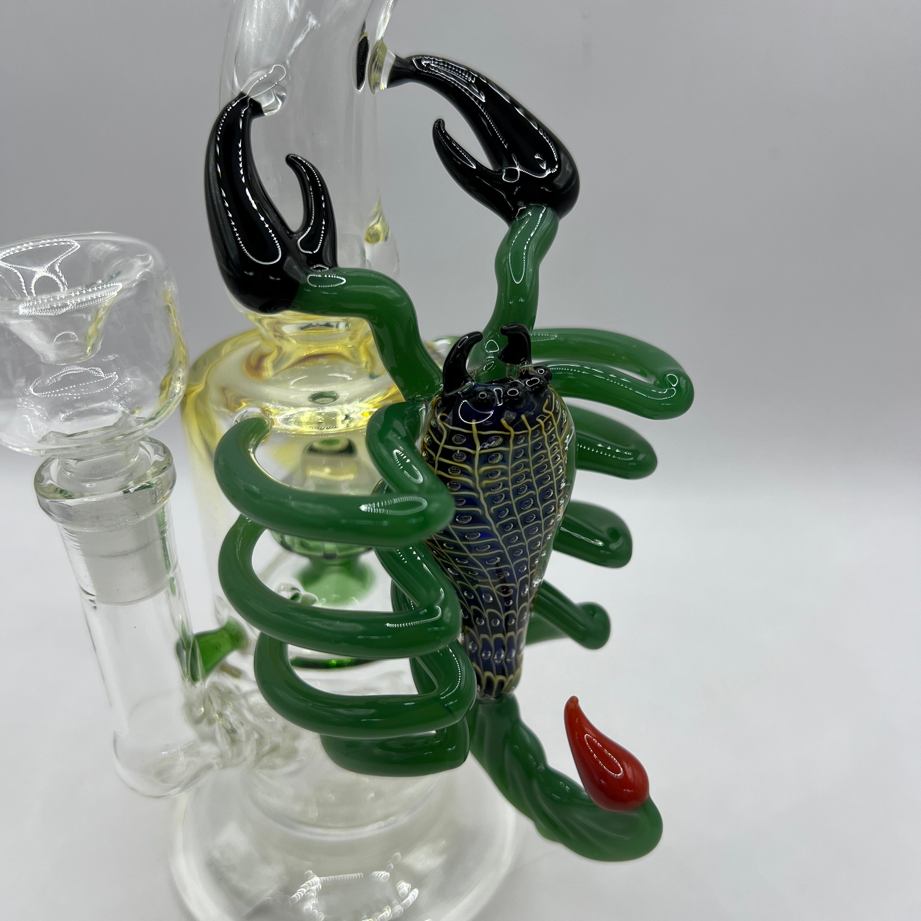 Detailed close-up of handcrafted scorpion sculpture wrapped around the glass chamber