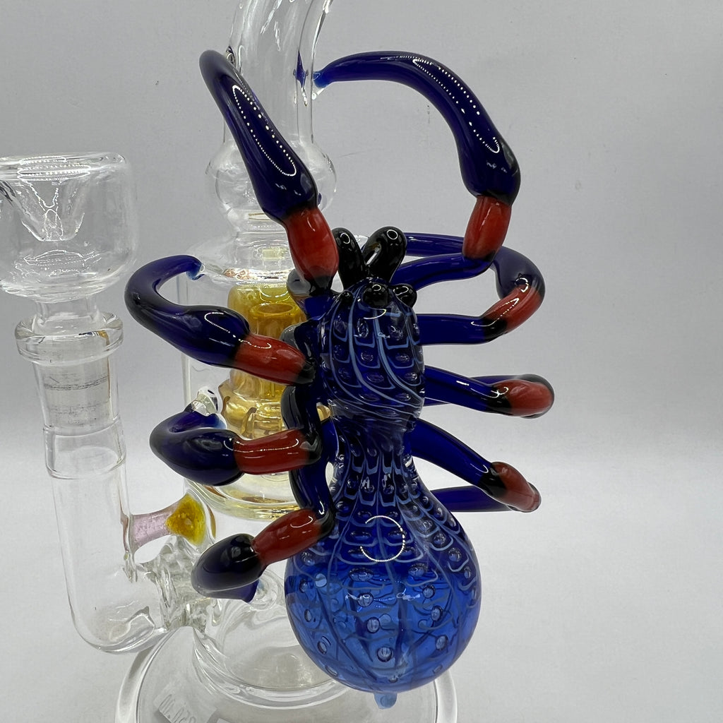 Close-up of handcrafted cobalt blue spider sculpture with detailed body and sculpted legs on OTG Glass water pipe