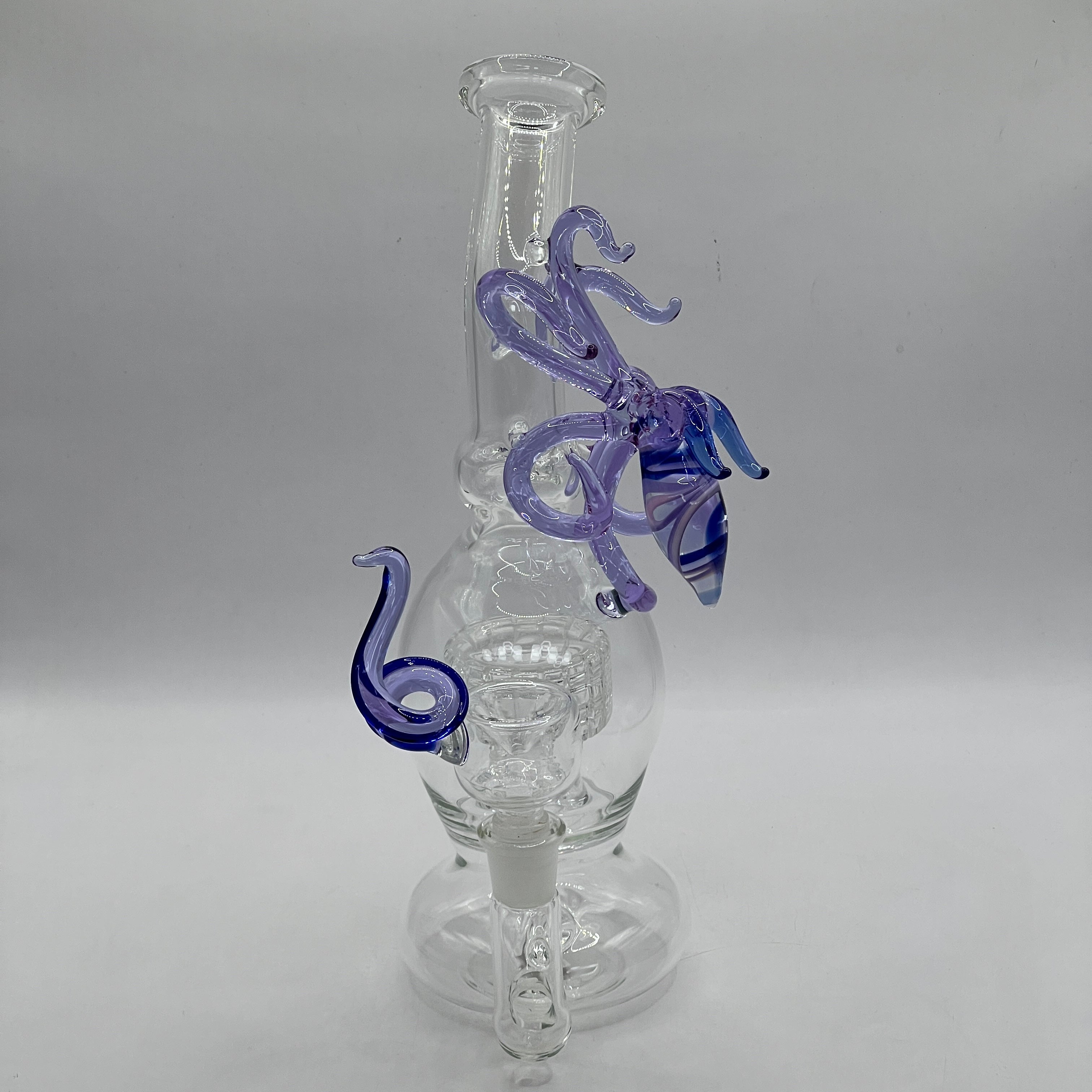 front view of handcrafted OTG Glass squid sculpture with flowing tentacles and striped blue body
