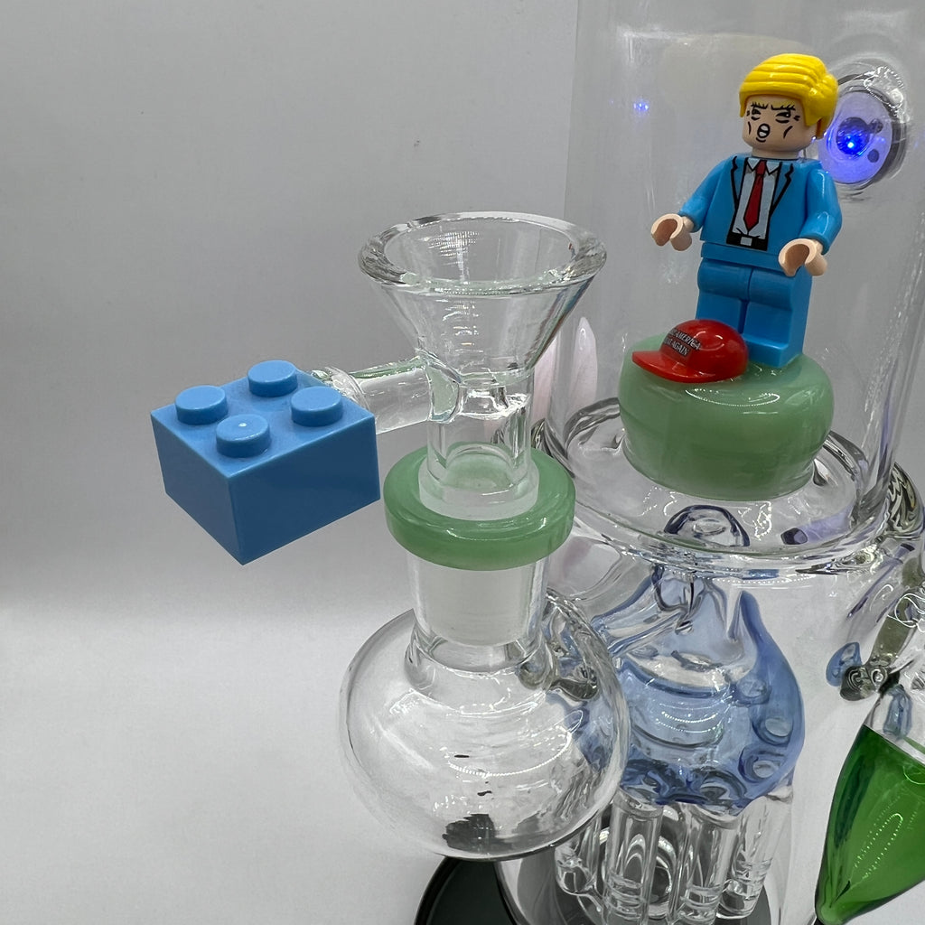 Three-quarter front view of Trump themed water pipe with large tree percolator and lego style bowl accent