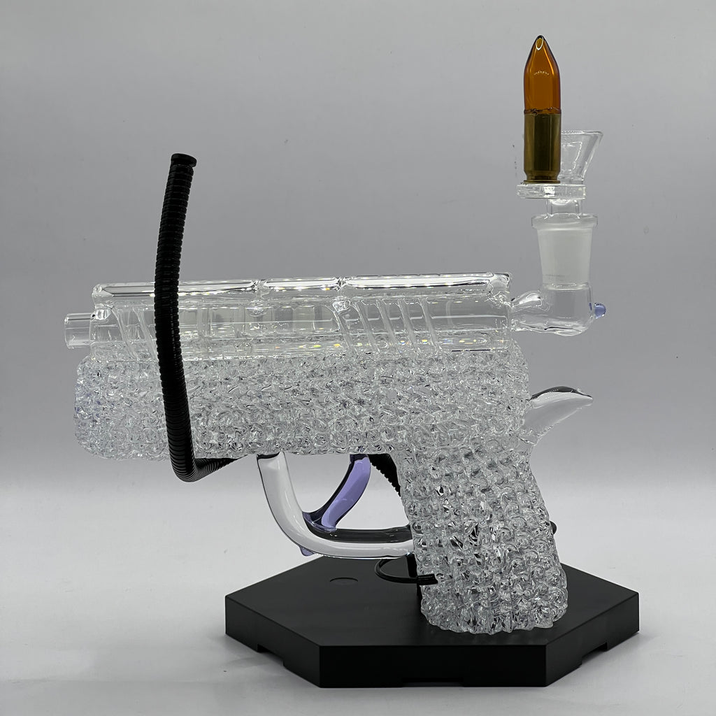 Side view of handcrafted OTG Glass .45 caliber handgun pipe with detailed slide, chaos texture, purple accents, and custom glass cartridge bowl.